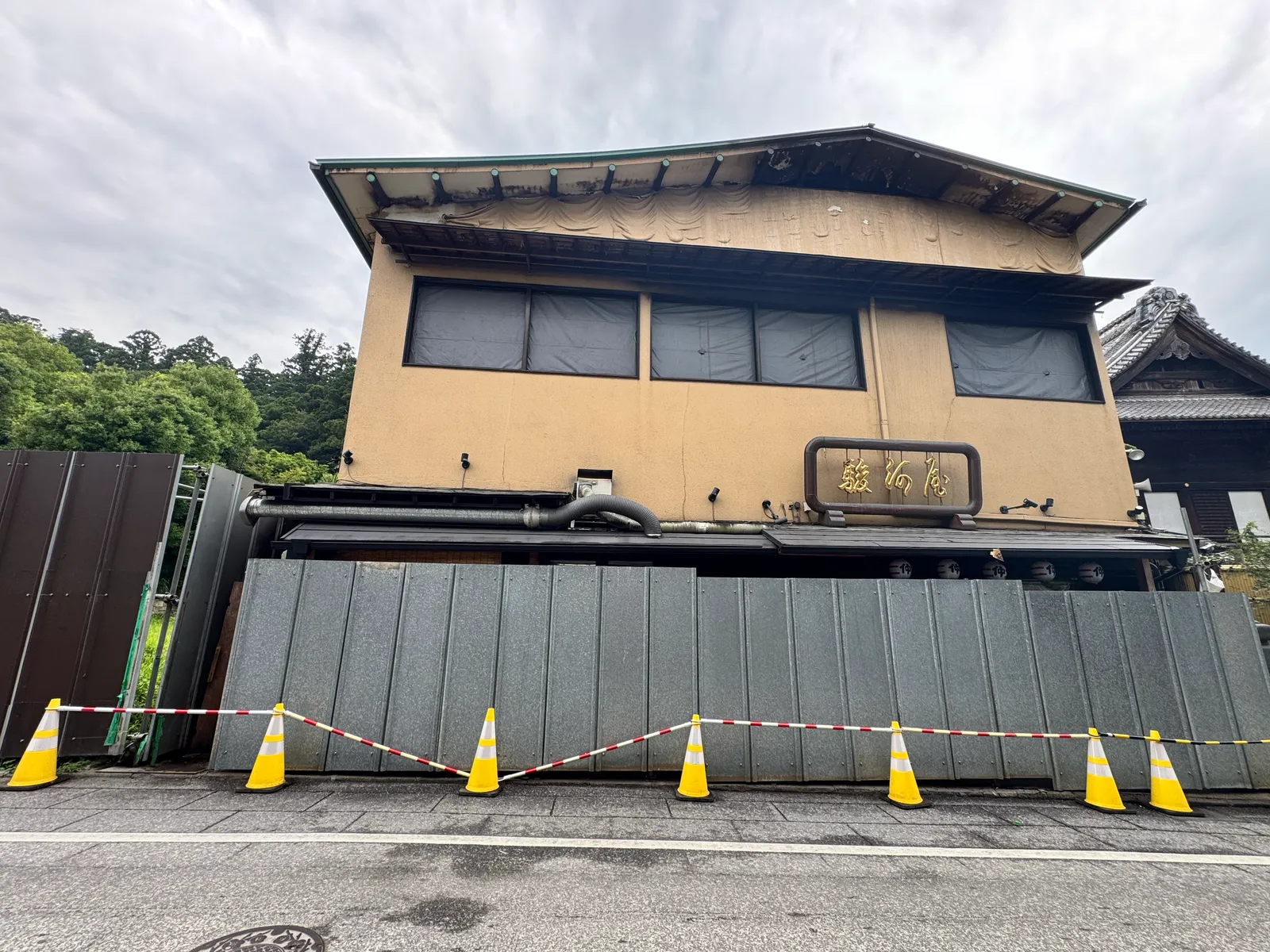 焼損した駿河屋の店舗正面。「駿河屋」の看板は残るが、軒下や窓に火災の跡が見える